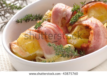 Freshly baked dish of potatoes rolled with bacon