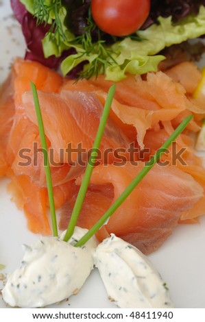 Fresh smoked salmon as appetizer in restaurant on white plate
