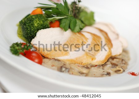 Chicken filled served with chanterelle sauce, rice and vegetables garnish in restaurant