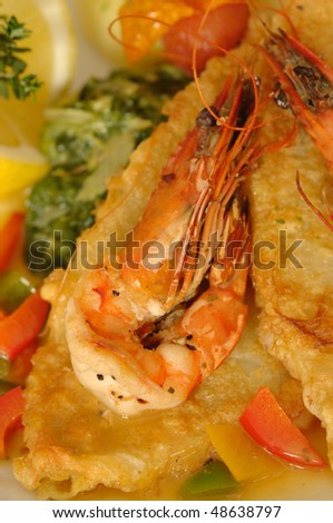 Fried sole fish with shrimps, potatoes, lemon served at restaurant