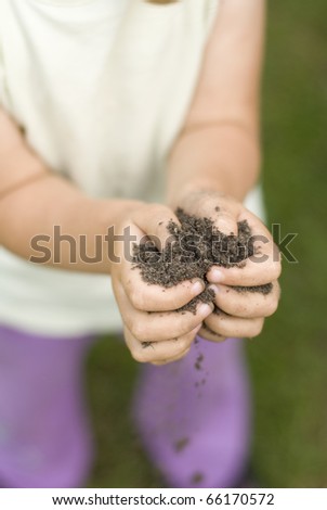 Small gorl holding dirt in her hands