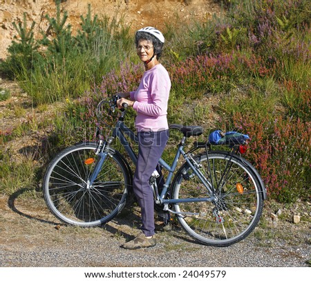 retired woman enjoying cycling through countryside