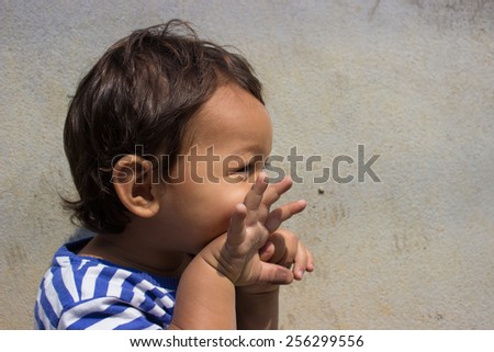 Toddler Making Funny Face With Hands In Front Of His Mouth Imitating A Fish