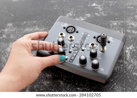 Audio interface for recording or mixing - sound/audio card - woman\'s hand holding audio plug - grunge background