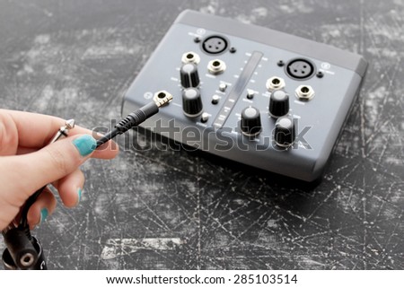 Audio interface for recording or mixing - sound/audio card, and woman's hand holding amplifier