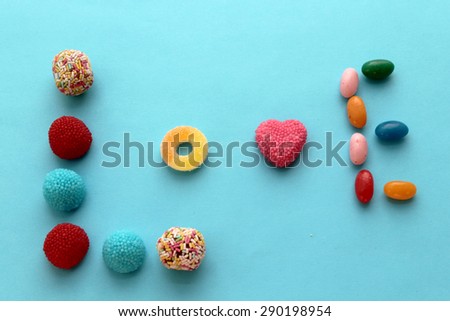 Word love made with candies - creative typography or writing - colorful - on blue vintage background