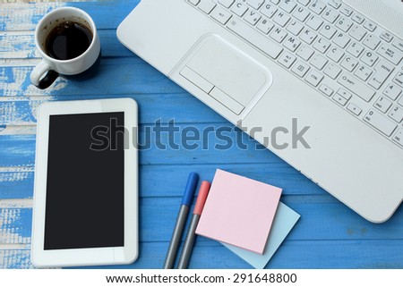 Lap top, black coffee, sticky note, pens and tablet
