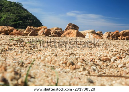 Ant\'s eye view on the tropical beach with rocks ahead.