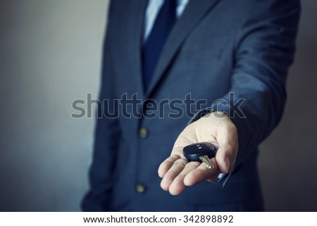 Businessman in suit giving a car key