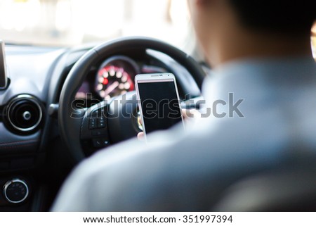 man using phone while driving the car (selective focus) - transportation and vehicle concept