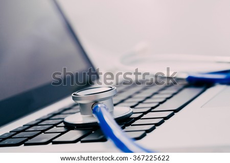 Stethoscope on laptop - Computer repair and maintenance concept - in dark tone