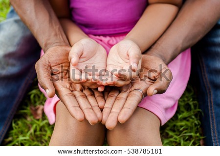 Hands of family together in green park - family unity and peace concept