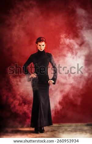 Beautiful Redhead woman posing in elegant long dress in studio