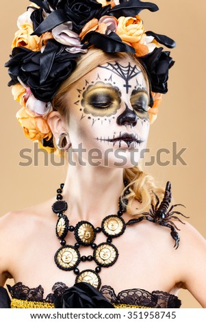 attractive young woman with sugar skull makeup. Mexican Day of the dead woman wearing sugar skull makeup and flower wreath.