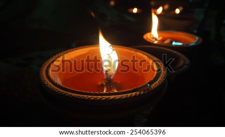 Closeup candles flame in clay pot for meditation at night, black background