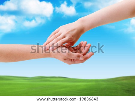 Hands of Man and Woman Holding Each other in front of a field