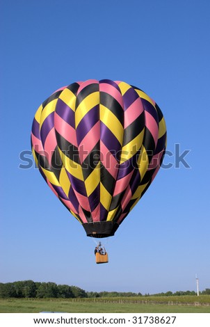 multi-colored hot air balloon just after lift off