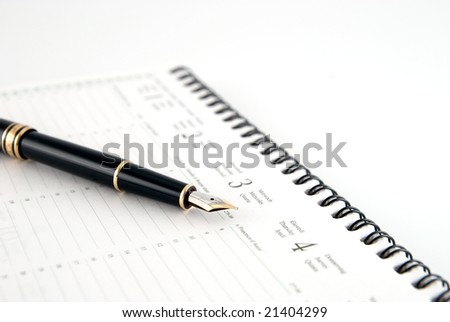 Pen and planner on white background