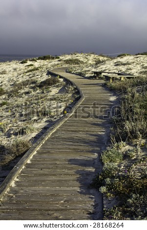 Boardwalk over sand dunes and cloudy sky on the California coast near Pacific Grove, California