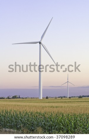 Two large windmills in a midwest cornfield with slight motion blur vertical