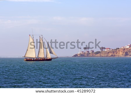 Schooner America sails from the Pacific Ocean past Point Loma at the Cabrillo National Monument near San Diego, California
