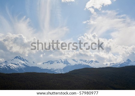 Peaks of the Tantalus Range at the southern end of the Coastal Mountains of British Columbia, Canada against a dramatic sky of backlit clouds