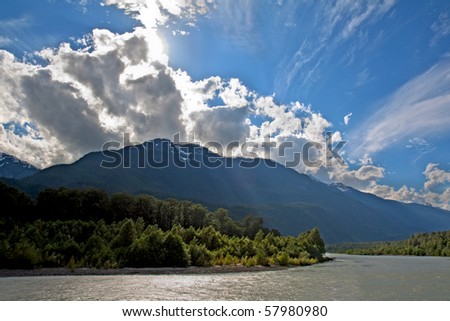 View of the Squamish River at Brackendale Eagles Provincial Park in British Columbia, Canada with sun flare behind dramatic clouds