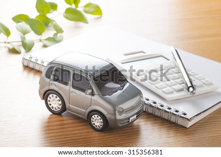 Toy car and calculator on the table.,to buy,sell,rent,repair or insurance