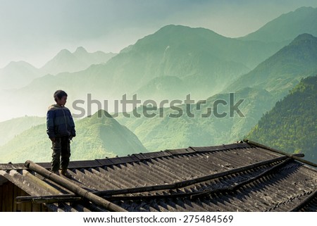 SAPA, VIETNAM - MARCH 18: Unidentified rural boy standing on rooftop at top of mountain on March 18, 2015 of Sapa, Vietnam.