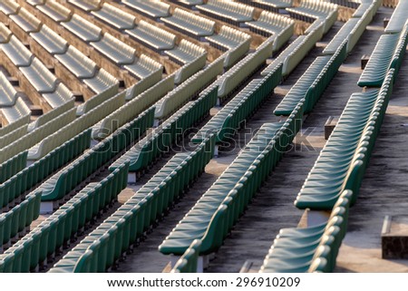 Empty seats in outdoor stadium during late afternoon.