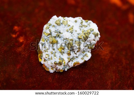 Mineral pyryte known as fool\'s gold sparking on piece of velvet cloth