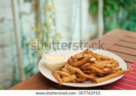 Home made french fries with dressing on wooden table