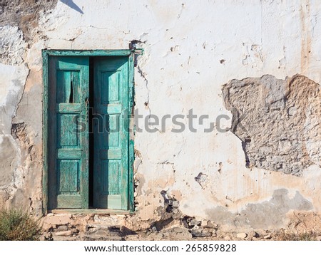 Old rotten house with a wooden green door
