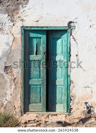 Wooden green door of an old rotten house