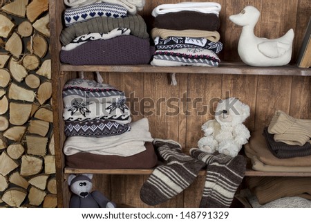 room with a cupboard with knitted clothes and books in a village house
