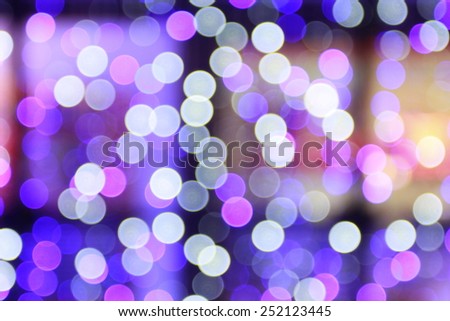 Festive blur background with natural bokeh and bright purple lights.