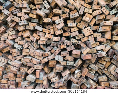 Storage of brown cut wood stack with rusty nails.