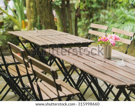 Warm tone color of wooden brown dining tables in outdoor garden.