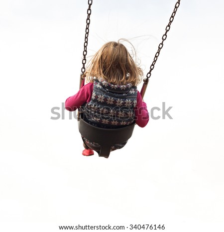 An isolated girl swinging high on a swing