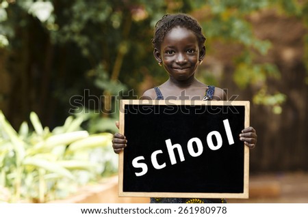 Back to School - African Child Holding Chalkboard Education. An African girl holding a blackboard, with plenty of copy space.