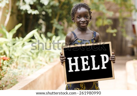 Help Symbol - African Girl and a Chalkboard.  Holding a blackboard in the streets of Bamako as a help symbol.