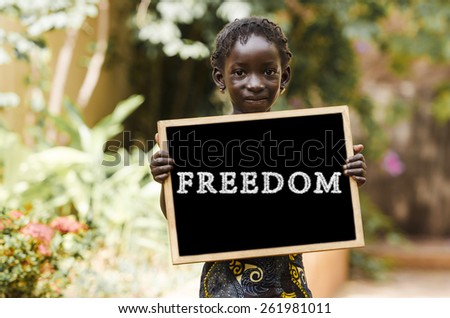 Freedom Symbol - African Girl Holding Chalkboard.  An African girl holding a blackboard.