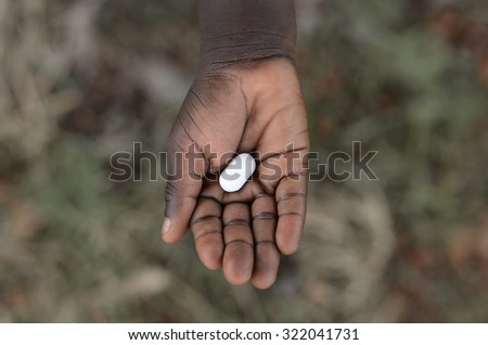 Medicine Health Curing Symbol Life African Black Girl Holding Pill. Unfortunately, in Africa there are lots of diseases like malaria, pneumonia, AIDS or simple Diarrhea.