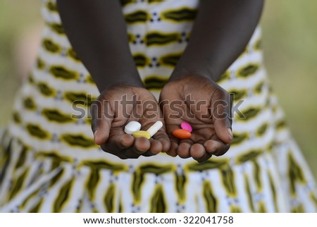 Black Girl Hands Cupped Medicine Health Background Symbol Pills Africa. Medicine Healthcare Symbol. Black African girl holding pills to cure diseases.