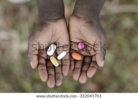 Curing Malaria - African Girl Holding Pills Medicine Health Symbol. Medicine and healthcare pills are very important in the black continent.