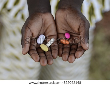 Healthy Lifestyle Medicine African Black Boy Holding Colorful Pills Background. Unfortunately, in Africa there are lots of diseases like malaria, pneumonia, AIDS or simple Diarrhea.