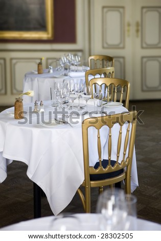 Dining tables with wine glasses and white tablecloths ready for guests