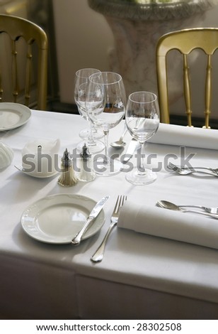 Dining table with wine glasses and white tablecloth ready for guests