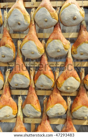 italian prosciutto hanging to dry in an italian butcher shop
