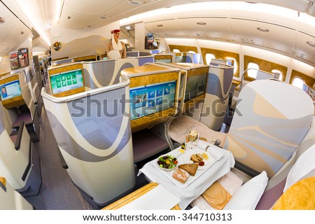 Dubai, UAE - NOVEMBER, 2015: Emirates Airbus A380 business class seats. Emirates A380 ICE in-flight entertainment system. Emirates cabin crew member, flight attendant on November 09, 2015 in Dubai
